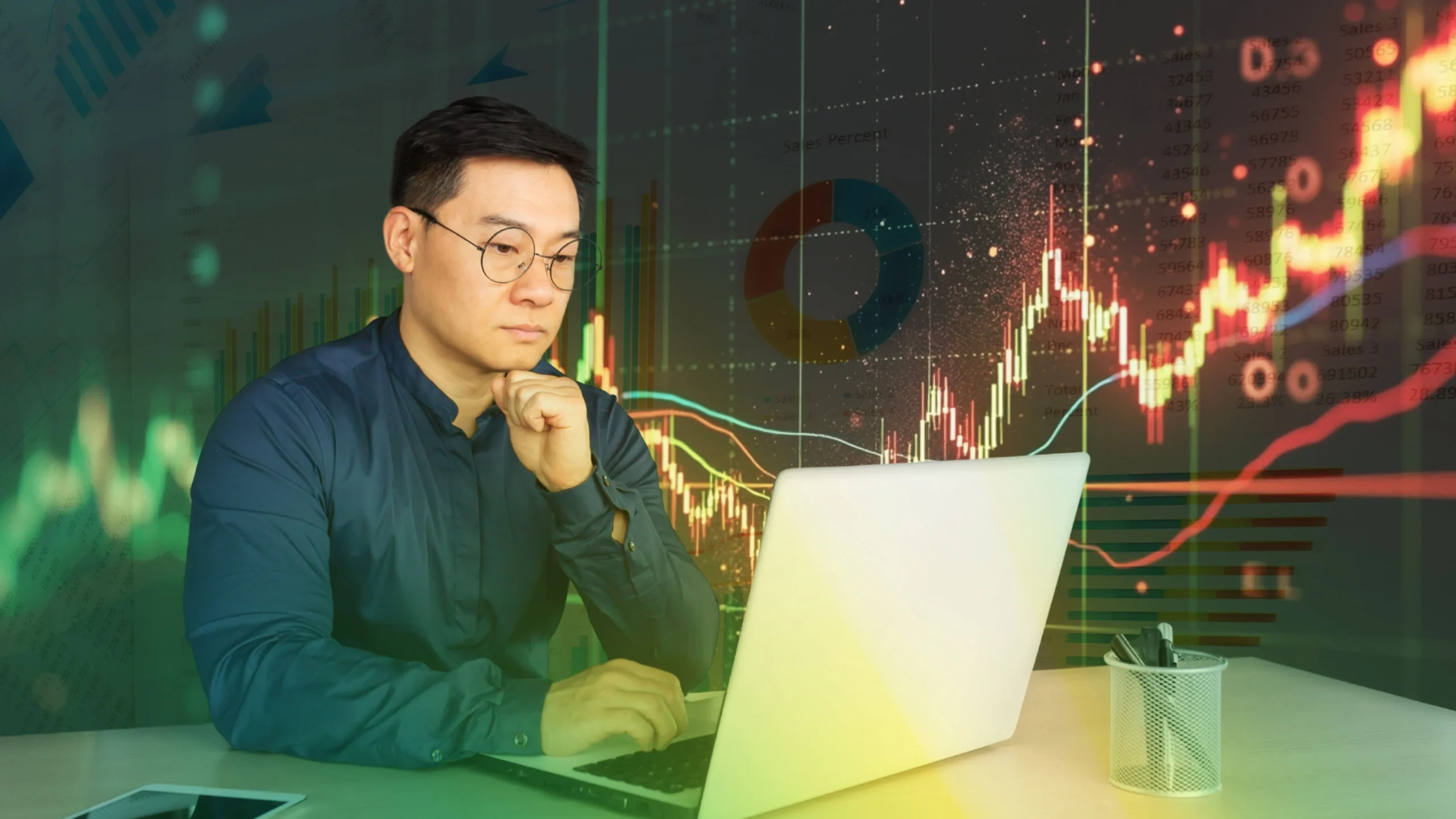 person looking at laptop for trading charts and stock market news